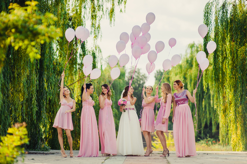 The bride with bridesmaids in pink dresses for a walk